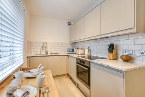 cocina con electrodomésticos blancos y mesa de madera en Oxted High St, en Titsey