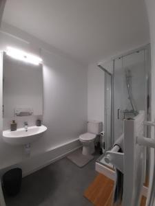 a white bathroom with a sink and a toilet at Résidence du Léon in Landivisiau