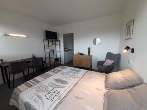 Schlafzimmer mit einem Bett, einem Schreibtisch und einem Stuhl in der Unterkunft Résidence du Léon in Landivisiau