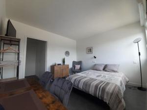 a bedroom with a bed and a desk and chairs at Résidence du Léon in Landivisiau +2 photos