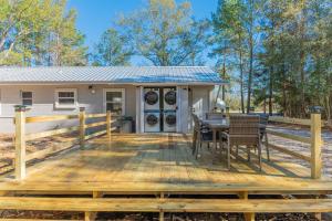 een terras met een tafel en stoelen en een huis bij Westville Pines Cabin 
