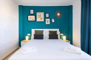 a bedroom with a large white bed with a blue wall at Ke Casetta Tenerife Emma House with jacuzzi in Callao Salvaje