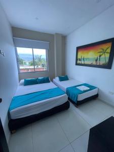 1 dormitorio con 2 camas y ventana grande en Cabanas Villa Antonella Covenas, en Coveñas