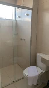 a bathroom with a toilet and a glass shower at Lazzarus Hotel in Alexânia