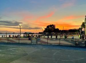 a group of people walking on the beach at sunset at Lovely vacation home 1 block from beach & downtown Gulfport in St. Petersburg