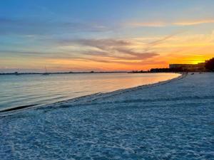 a beach with a sunset in the background at Lovely vacation home 1 block from beach & downtown Gulfport in St. Petersburg