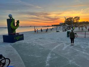 a group of people on the beach at sunset at Lovely vacation home 1 block from beach & downtown Gulfport in St. Petersburg