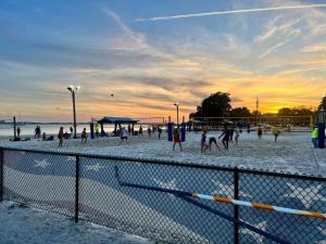a group of people playing volleyball on the beach at Lovely vacation home 1 block from beach & downtown Gulfport in St. Petersburg +39 photos