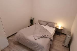 Un dormitorio con una cama blanca con luz. en Spacious 2 Bedroom Apartment with Court yard - Antwerp Smooth Stays, en Amberes