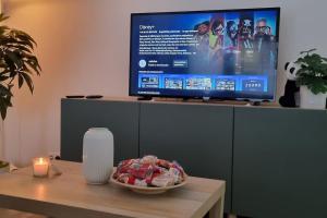 a television on top of a table with a bowl of food at Spacious 2 Bedroom Apartment with Court yard - Antwerp Smooth Stays in Antwerp
