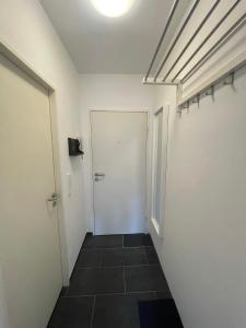 korytarz z drzwiami i podłogą wyłożoną kafelkami w obiekcie Premium Studio Grafenberg w mieście Düsseldorf