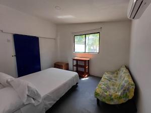 a small bedroom with two beds and a window at Punta Arena Beach Hostel in Playa Punta Arena