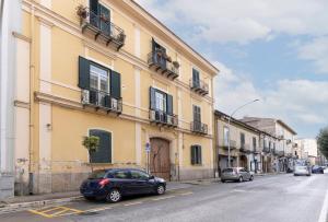 een zwarte auto geparkeerd voor een geel gebouw bij Gli Appartamenti della Villa in Santa Maria Capua Vetere