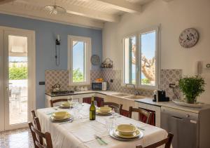 a kitchen with a table with a white table cloth at Villa Antico Pozzo piscina privata SPA in Castellammare del Golfo