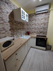 a kitchen with a sink and a microwave on a counter at Casa Ciano in Foggia