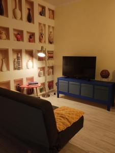 a living room with a flat screen tv on a blue cabinet at Casa Ciano in Foggia