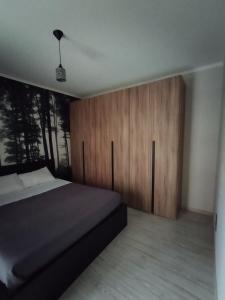 1 dormitorio con 1 cama y armario de madera en Casa Ciano en Foggia