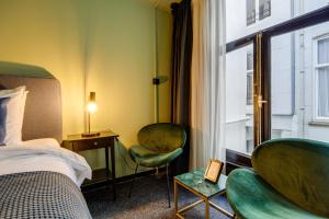 una camera d'albergo con un letto e due sedie e una finestra di SeventyFive ad Amsterdam
