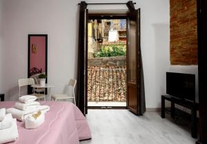a bedroom with a pink bed and a door to a patio at Mirose's holiday home 39 in Castelbuono