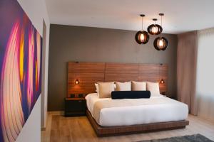 um quarto com uma grande cama branca e uma cabeceira em madeira em Ilo Rojo Hotel Boutique em San Miguel de Allende