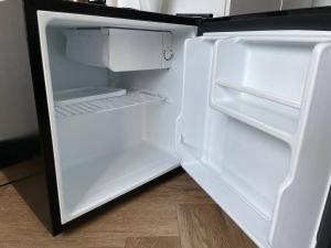 een lege koelkast met de deur open in een kamer bij Severini Studio With Own Kitchen & Bathroom in Tilburg