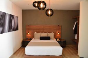 een slaapkamer met een groot bed en 2 lampen bij Ilo Rojo Hotel Boutique in San Miguel de Allende