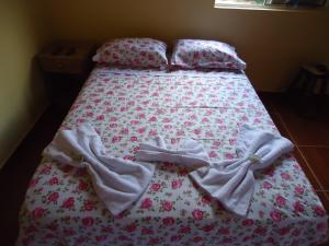 Una cama con manta y almohadas. en Pousada Maria Francisca en Santa Bárbara