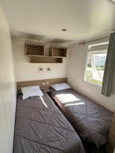 two beds in a small room with a window at Le Neptune in Argelès-sur-Mer