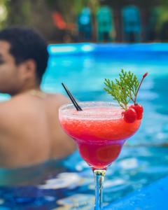 a red drink in a martini glass next to a pool at Los Vados Hotel in Managua