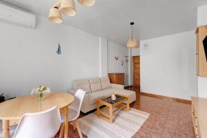 a living room with a table and a couch at A spacious and cozy apartment. in Torrevieja