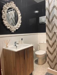 a bathroom with a sink and a toilet and a mirror at O fogar do camiñante in Redondela