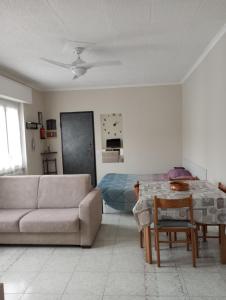 ein Wohnzimmer mit einem Sofa und einem Tisch in der Unterkunft Casa vacanze il fiore di loto in Zibido San Giacomo