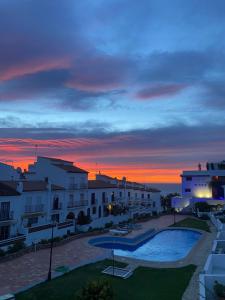 een uitzicht op een gebouw met een zonsondergang op de achtergrond bij Apartamento El Primer Sol in Nerja