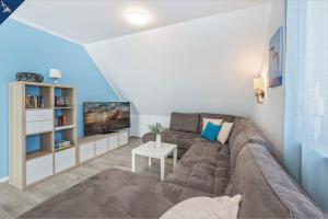 ein Wohnzimmer mit einem Sofa und einem TV in der Unterkunft Ferienanlage Sonneninsel Haus Himmelblau Obergeschoss in Loddin