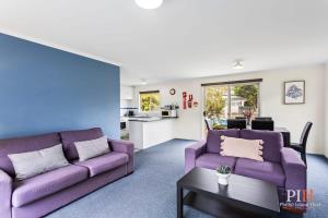考斯的住宿－Phillip Island Family Resort 2Bdr，客厅配有两张紫色沙发和一张桌子