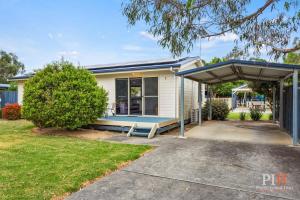 ein Haus mit einem blauen Dach und einer Veranda in der Unterkunft Phillip Island Family Resort 2Bdr in Cowes