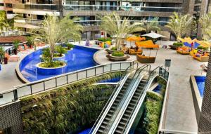 a resort with a swimming pool and an escalator at 2201 - Vista mar lateral! Apto para 5 pessoas com ar e vaga in Fortaleza