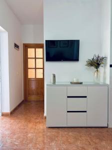 cocina con encimera blanca y TV en la pared en Roque's House, en Telde