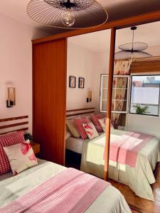 - une chambre avec 2 lits et un miroir dans l'établissement Roque's House, à Telde