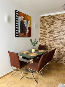 une salle à manger avec une table, des chaises et un tableau dans l'établissement Roque's House, à Telde