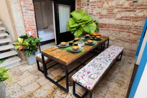 a table and bench on a patio with food on it at Casa Familiar - Maria de las Palmas -Getsemani in Cartagena de Indias