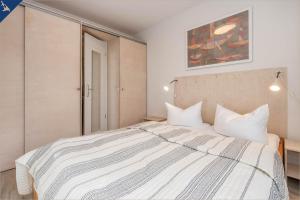 ein Schlafzimmer mit einem großen Bett mit weißer Bettwäsche in der Unterkunft Ferienanlage Seeblick Kunstquartier in Ostseebad Koserow