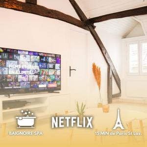 a flat screen tv on a wall in a living room at Chalet Lutétia, SPA & confort in Cormeilles-en-Parisis