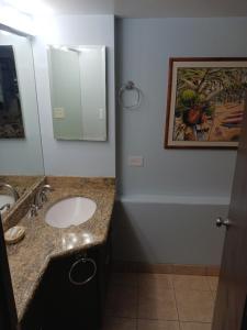 a bathroom with a sink and a mirror at Diamond Head Beach Hotel in Honolulu