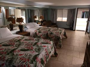 a hotel room with two beds and a couch at Diamond Head Beach Hotel in Honolulu