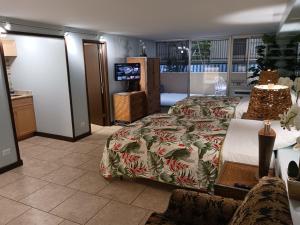 1 dormitorio con 1 cama y TV en Diamond Head Beach Hotel en Honolulu