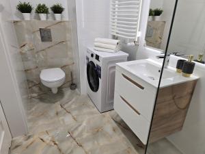 ein Badezimmer mit einer Waschmaschine und einem Waschbecken in der Unterkunft Ekskluzywny apartament + garaż in Krakau