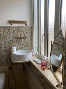 Casa Vacanze Sharazad في Bocchignano: حمام مع حوض ومرآة على منضدة