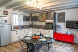 y cocina con mesa, sillas y nevera. en Chez tonton Henri, maison de pêcheur, en Saint-Valery-sur-Somme