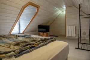 1 dormitorio con 1 cama y TV en el ático en Chez tonton Henri, maison de pêcheur, en Saint-Valery-sur-Somme